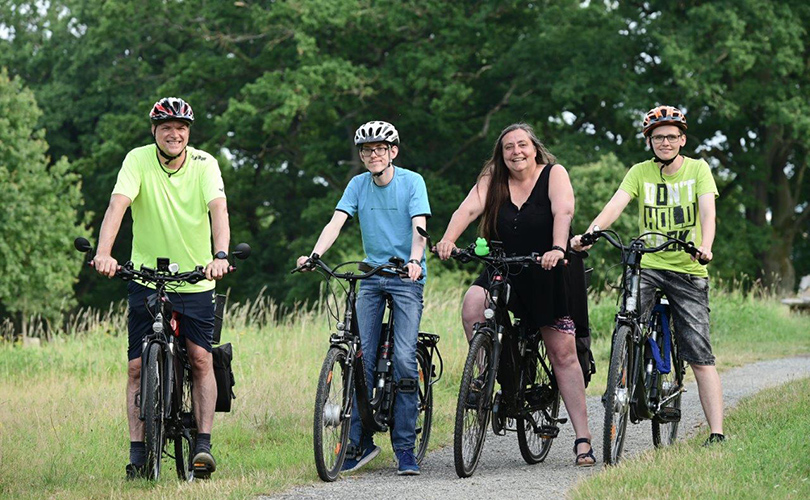 Eine Familie mit vier Personen macht eine Fahrradtour.