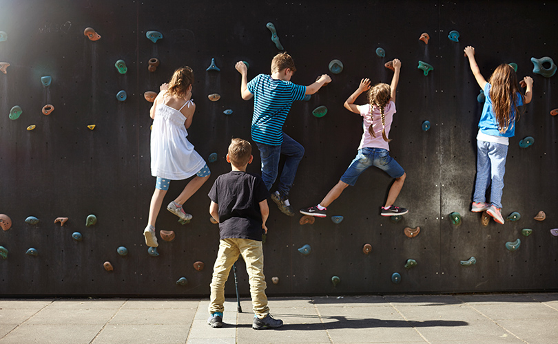 Kinder Bouldern an einer Kletterwand.