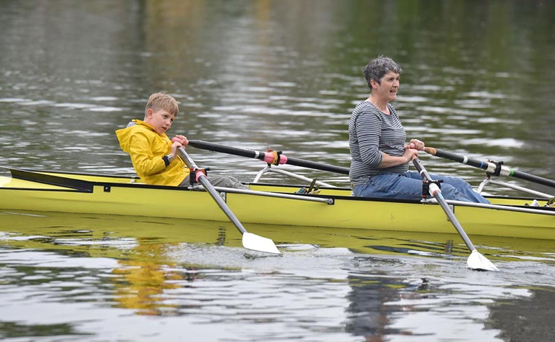 Ein Junge und eine Frau Rudern in einem Boot